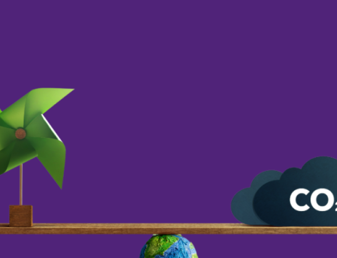 A green windmill on the left and a dark cloud labeled “CO₂” on the right are balanced on a wooden plank. The plank is supported by a small Earth globe at the center, symbolizing the balance between renewable energy and carbon emissions. The background is solid purple.